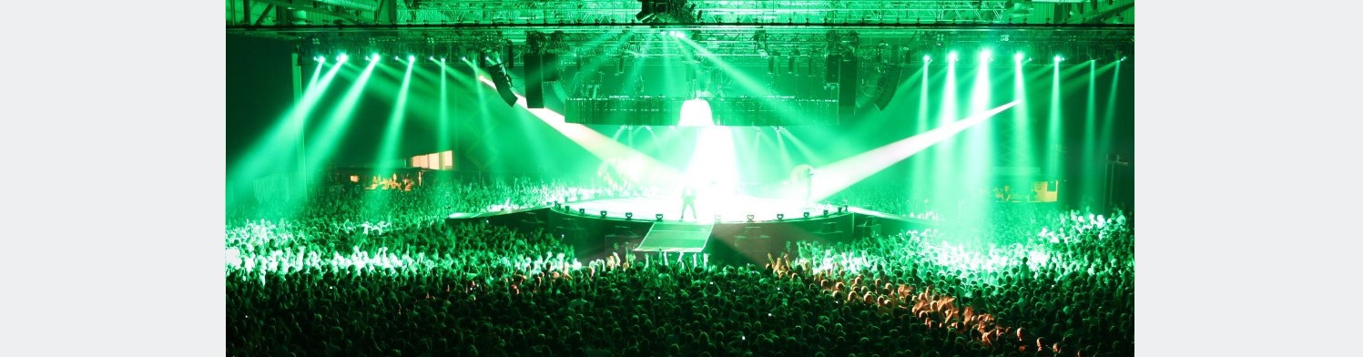 Live-Konzert vor sehr großem Publikum. Bühne in grünes Licht gehüllt.