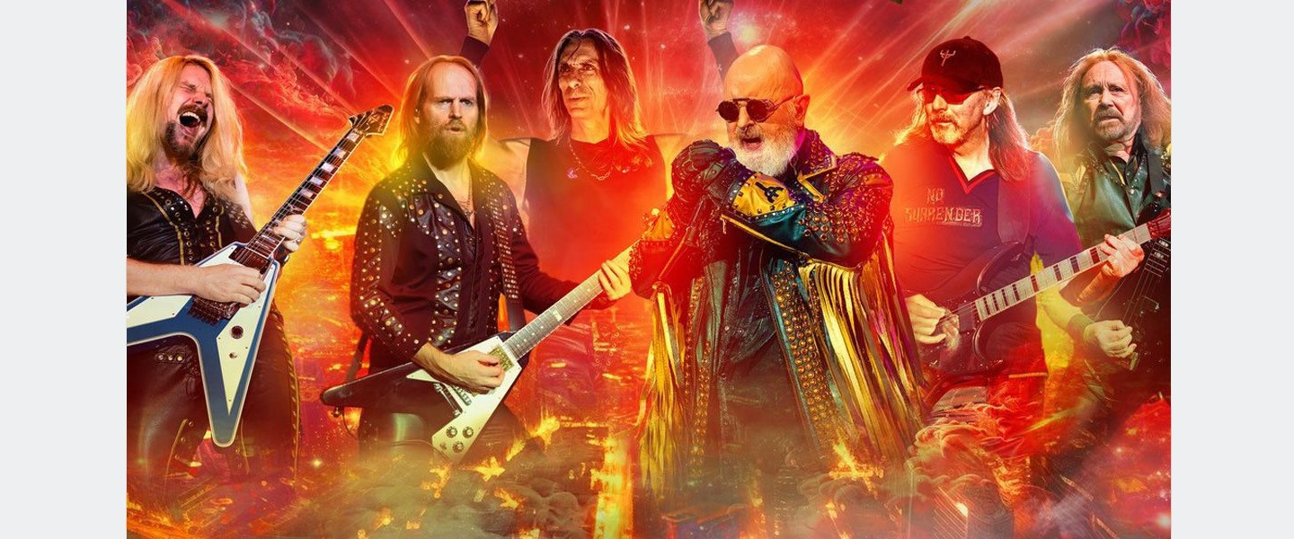 Rockband Judas Priest live auf der Bühne in Flammenmeer mit Instrumenten.